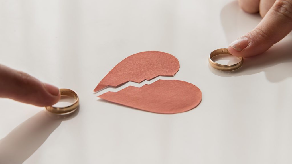 Allongé, les mains jointes, les alliances-divorce