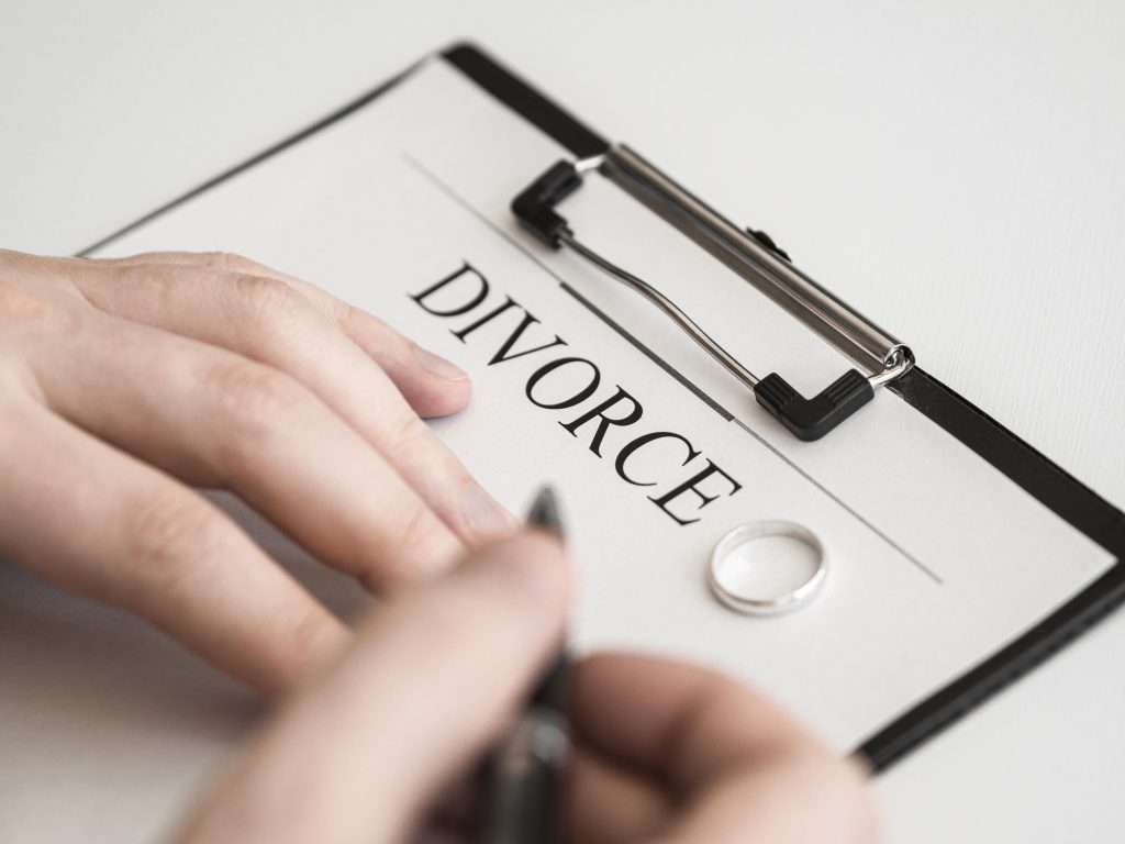 Gros plan sur un homme signant un contrat de divorce